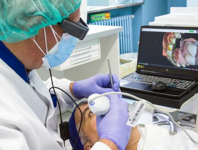 a person in a mask and gloves using a laptop